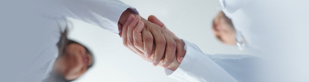 Healthcare Professionals Shaking Hands Representing Partnership And Trust